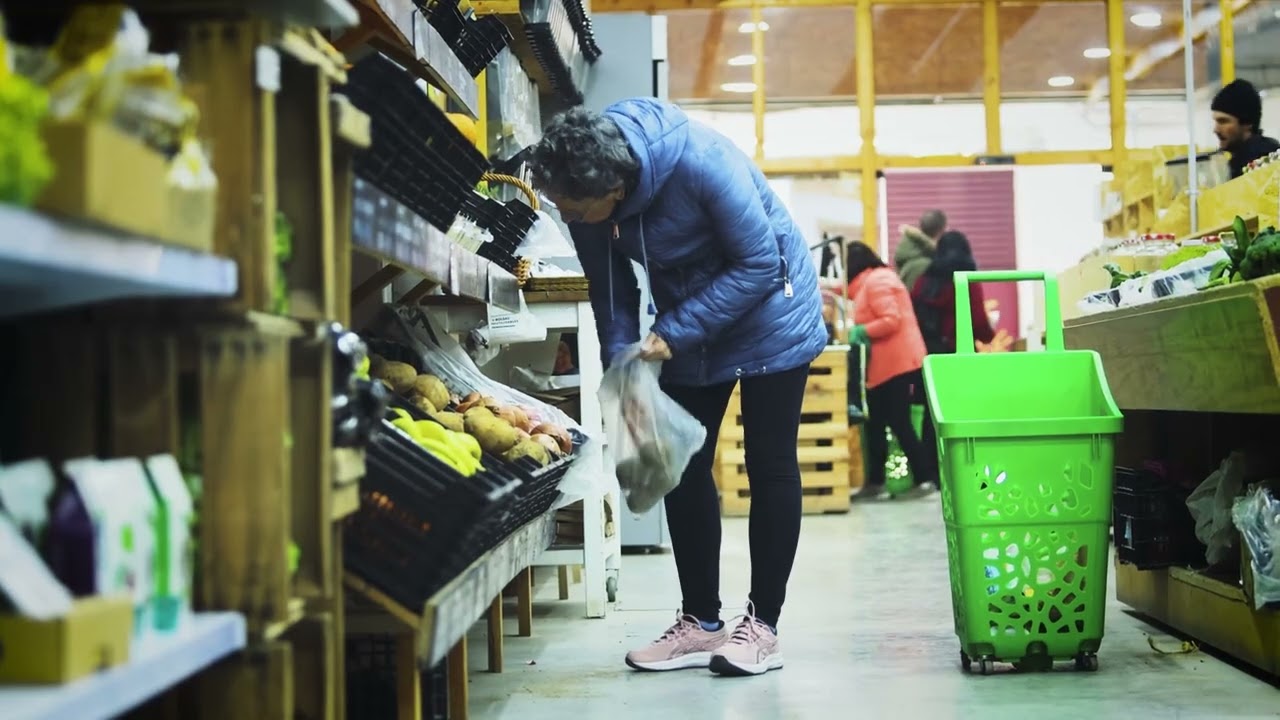 Persona comprando frutas y verduras en A Vecinal, supermercado cooperativo agroecológico en Aragón.