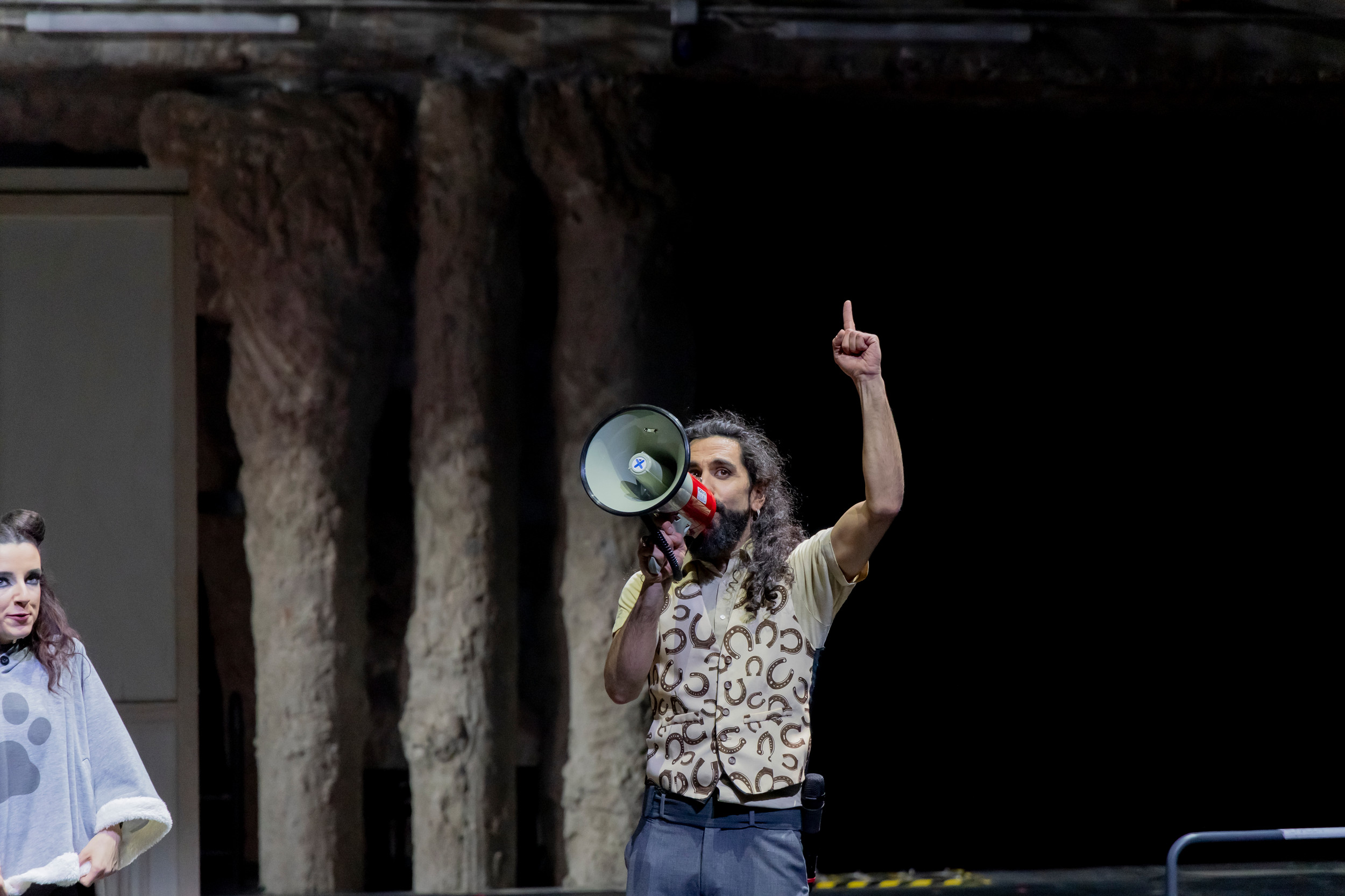 ctor de LaJoven en escena con megáfono durante una función teatral contemporánea del proyecto teatral español LaJoven.