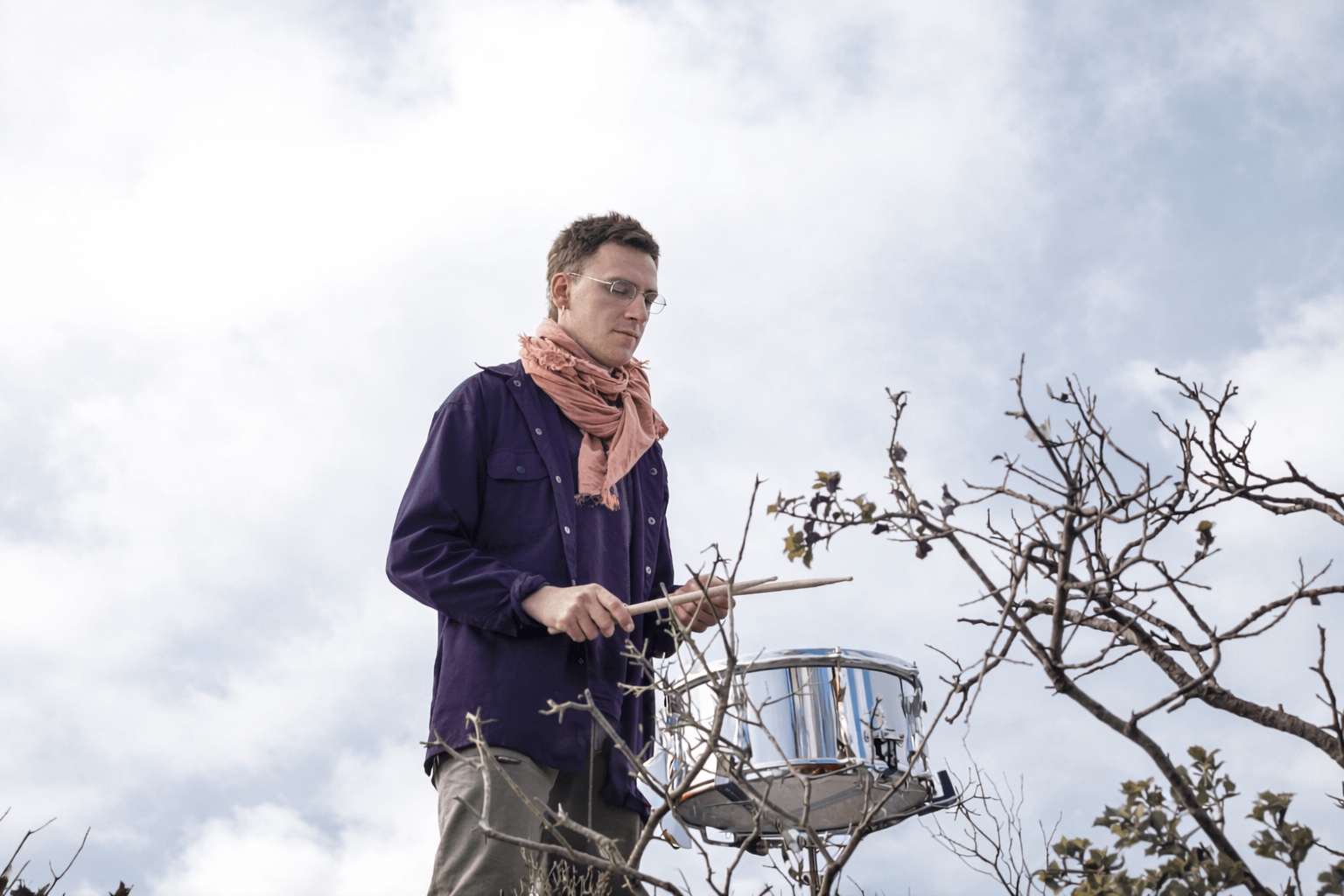 AADK SONORA en Blanca: Andrés Navarro toca una caja en una práctica sonora al aire libre entre ramas